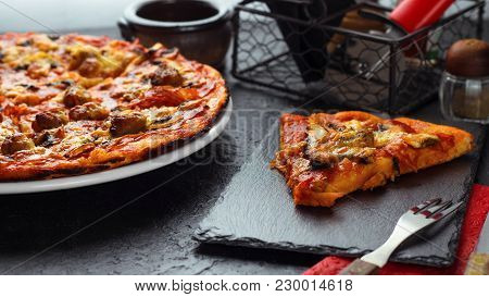 Homemade Pizza With Chorizo, Mushrooms, Mozzarella And Pieces Of Chipolata Sausages On Dark Table.