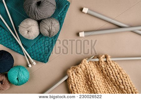 Grey And Turquoise Balls Wool And Knitting On Needles On Beige Background. Knitting As A Kind Of Nee