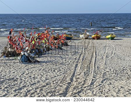 Fishing Boats With Nets And Flags On The Baltic Shore.