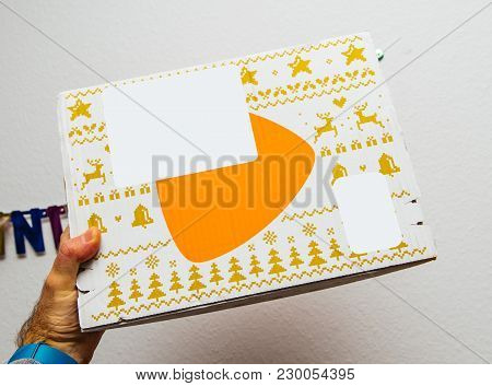 Paris, France - Jan 1, 2018: Man Holding Against White Background A Box Containing Fashion Clothes B