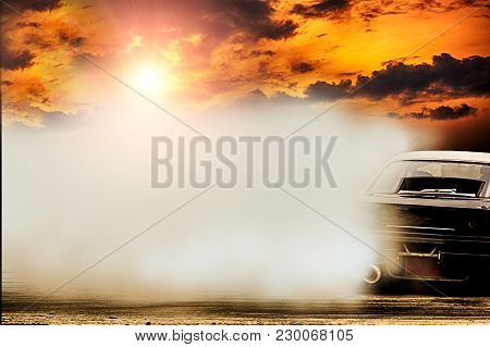 Abstract Blurred Drift Car With Smoke From Burned Tire At Sunset.