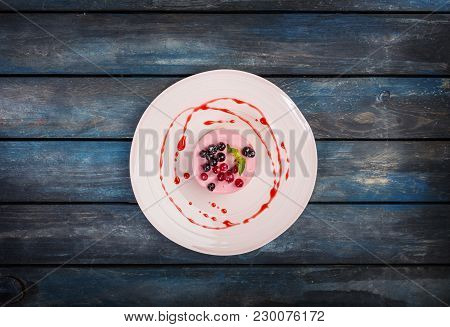 Caramel Cheesecake With Strawberry On The White Plate With Colored Wooden Background. Top View