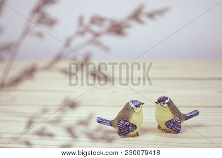 A Little Two Ceramic Birds On Wooden Table. Focus On Bird.