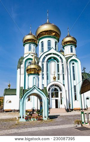 White church with gold domes a part of the European architecture. Russian orthodox church with typical golden onion domes
