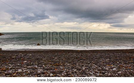 Black Pebbles Beach Calm Sea, Grey Sunset  In Iceland. Summer In Iceland.