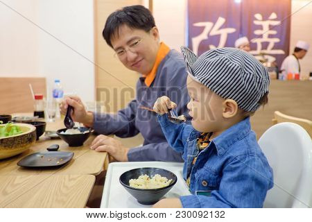 Cute Asian 18 Months Toddler Baby Boy Child Eating Food With Fork & Spoon By Himself At Japanese Res