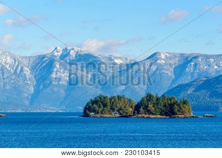 Fantastic view over ocean, snow mountain and rocks at Sechelt inlet in Vancouver, Canada.