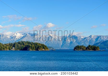 Fantastic view over ocean, snow mountain and rocks at Sechelt inlet in Vancouver, Canada.