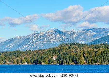 Fantastic view over ocean, snow mountain and rocks at Sechelt inlet in Vancouver, Canada.
