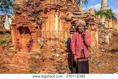 Ava, Myanmar - January 27, 2016 : Old Wrinkled Woman Smokes  A Cheroot Cigar Around Ruined Temples I