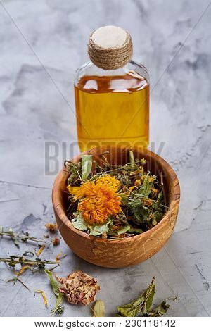 Spa Still Life With Flowers In Wooden Bowl And Two Oil Jars On Light Textured Background, Top View, 