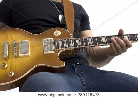 Man With Electric Guitar Sitting Isolated Over White.
