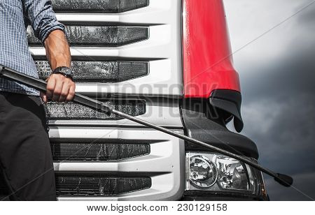 Manual Truck Washing Using High Pressure Cleaner. Taking Care Of Truck Concept With Caucasian Driver