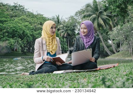 Portrait Of Young Lovely Pleasant Mix Ethnic Woman Sitting On Grass At Summer Green Park And Having 