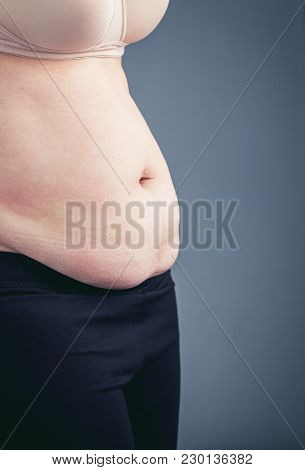 Woman's Body With Excessive Belly Fat, Grey Background. Vintage Tone.