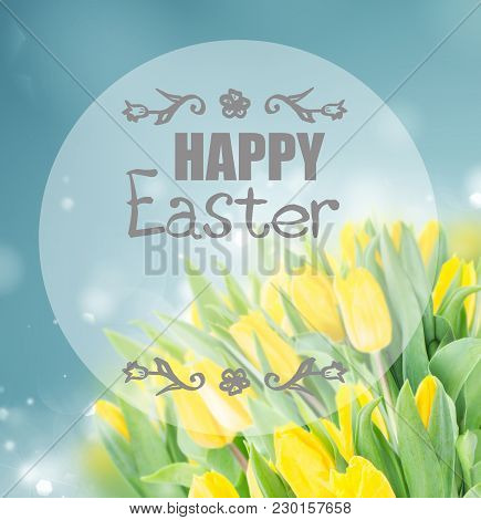 Spring Yellow Tulips In Garden On Blue Bokeh Background With Happy Easter Greeting