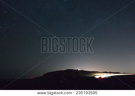 Well-known Landmark Belle Tout Lighthouse On The Sussex Coast, With Starry Sky, Red Glow On Horizon 