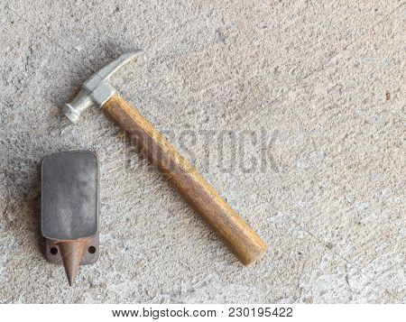 Old Small Hammer And Miniature Anvil With Concrete Background
