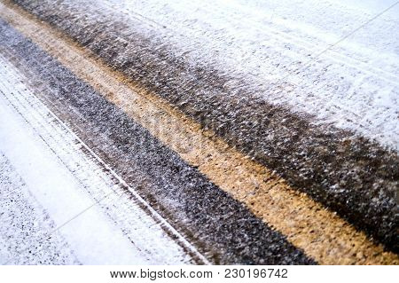 Tracks In Snow On Winter Asphalt Road.