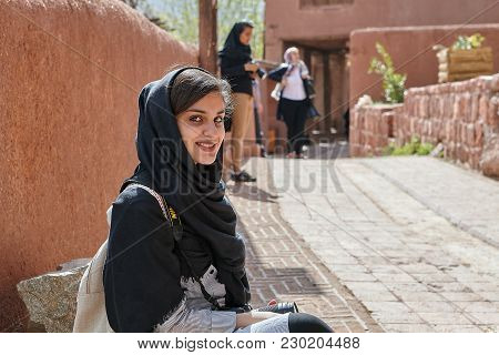 Abyaneh, Iran - April 26, 2017: Young Iranian Woman In Hijab Sits In Traditional Village In Mountain