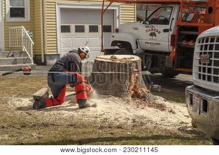 Somerset, Masschusetts, Usa - March 31, 2015: Landscaper Cutting Away At Base Of Stubborn Stump