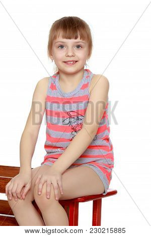 Beautiful Little Caucasian Girl With A Short Bangs And Hair Tucked Into A Tail. In Striped In A T-sh