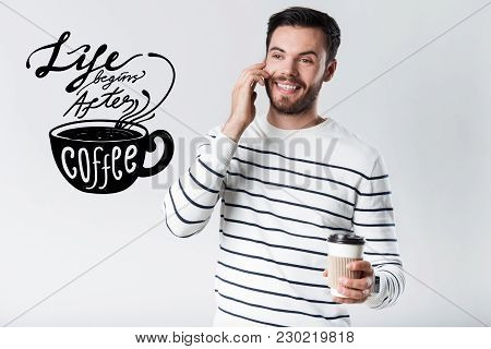 Pleasant Talk. Handsome Young Positive Man Smiling And Feeling Pleased While Talking On The Phone An