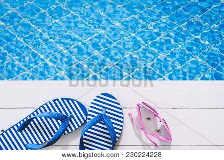 Flip-flops And Sunglasses On The Swimming Pool