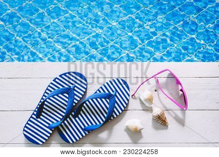 Flip-flops And Sunglasses On The Swimming Pool