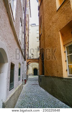 Old Narrow Cobbled Laneway Between Tall Buildings In Old Town Salzburg, Austria.