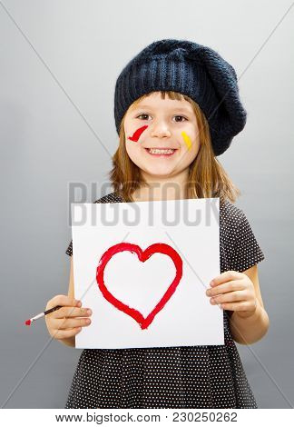 Little Painter Girl With A Drwan Heart Isolated On Grey