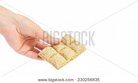 Sesame Brittles Brick In Hand Isolated On White Background. Copy Space, Template.