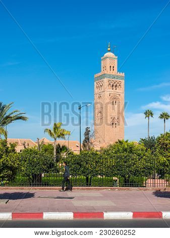 Marrakesh, Morocco - December 8, 2016: A Pedestrian In The Background Of The Koutoubia Mosque (kutub