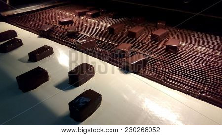 Chocolate Sweets Go On The Conveyor. Sweets On The Conveyor. Chocolate Sweets Are Moving On The Conv