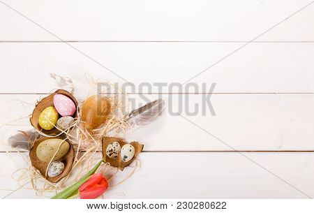Easter Background With Easter Eggs, Bird Feather And Spring Flowers. Top View With Copy Space