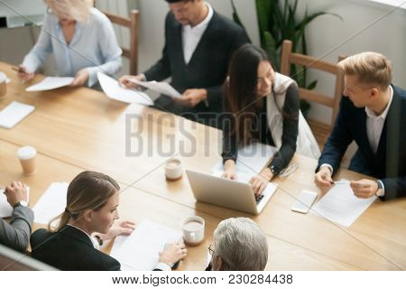 Diverse Multiracial Business Team Preparing For Group Meeting Sitting Together At Conference Table, 