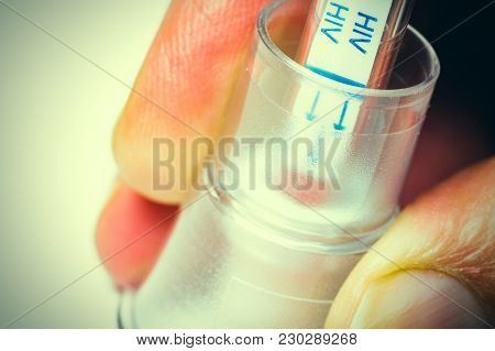 A Hand Holding An Hiv Self-test With Blood Inside On Vintage Effect