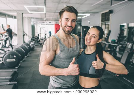Trainer And Her Student Are Standing In The Sport Club's Training Room Together And Showing Their Bi