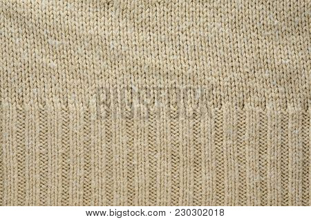 Beige Texture of a Knitted Sweater with Two Types of Knitting. Knit texture as background.
