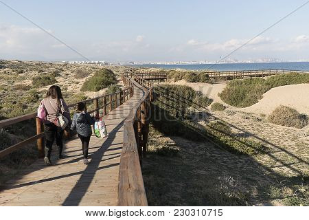 People Walking Through The Wooden Walkway In The Arenales Del Sol.