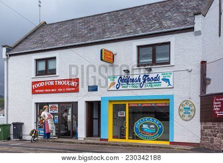 Ullapool, Scotland - June 8, 2012: White Houses In Street Are Butcher And Fish Shop. Colorful Advert
