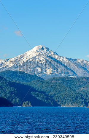 Fantastic view over ocean, snow mountain and rocks at Sechelt inlet in Vancouver, Canada.