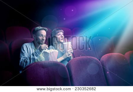 Teenager couple cuddling and watching the climax part of the movie