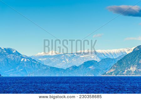 Fantastic view over ocean, snow mountain and rocks at Sechelt inlet in Vancouver, Canada.