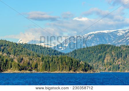 Fantastic view over ocean, snow mountain and rocks at Sechelt inlet in Vancouver, Canada.