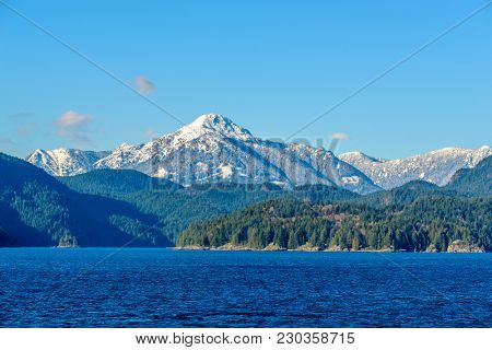 Fantastic view over ocean, snow mountain and rocks at Sechelt inlet in Vancouver, Canada.