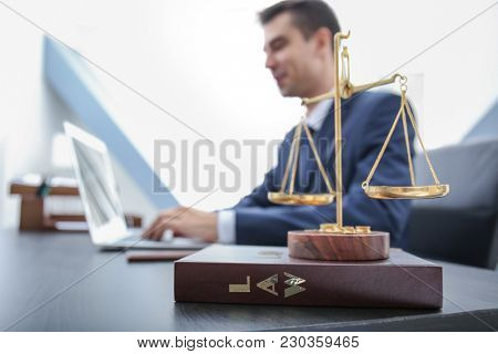 Scales of justice and juridical book on table in lawyer's office
