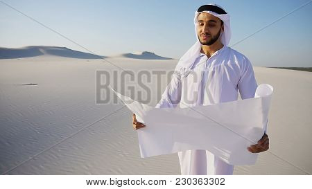 Beautiful Emirate Sheikh Businessman Studying Project Of Future Construction Of Complex, Standing In