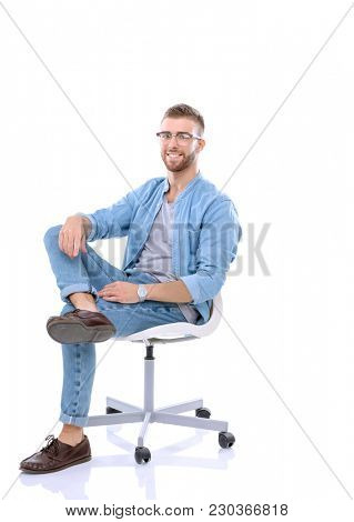 Young man sitting on the chair isolated over white background. Startupper. Young entrepreneur.