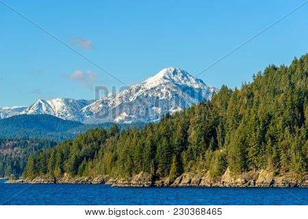 Fantastic view over ocean, snow mountain and rocks at Sechelt inlet in Vancouver, Canada.